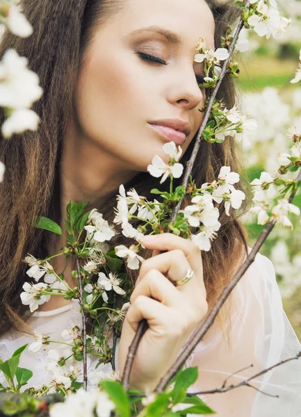 Mujer atractiva oliendo flores silvestres — Foto de Stock