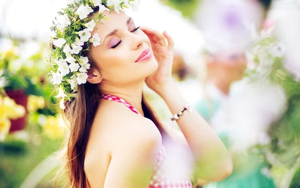 頭にカラフルな花輪を持つかなりブルネットの女性 — ストック写真