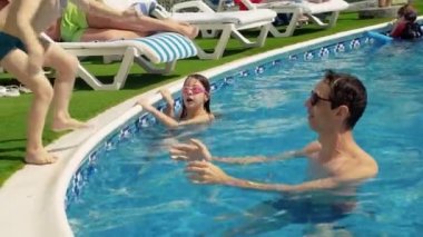 Babasıyla yüzme havuzunda oynayan çocuklar..