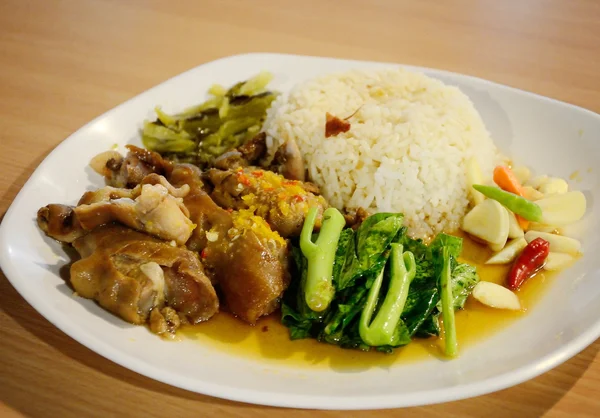 Perna de porco com arroz com legumes em prato branco — Fotografia de Stock