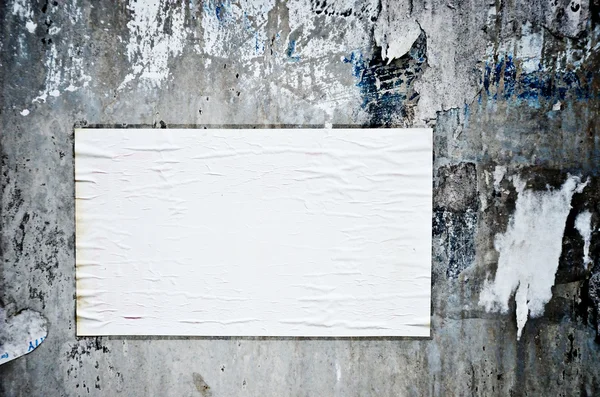 汚れた壁に空白の紙の棒 — ストック写真
