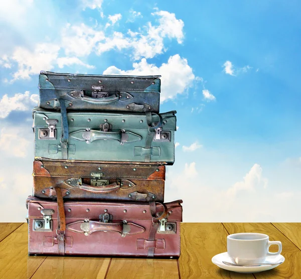 Ready for travel in morning concept, Old travel bag and coffee cup on wooden table — Stock Photo, Image