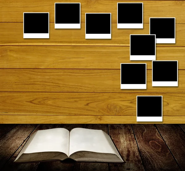 Lesebuch mit Fotorahmen an Holzwand, Lesetischkonzept — Stockfoto