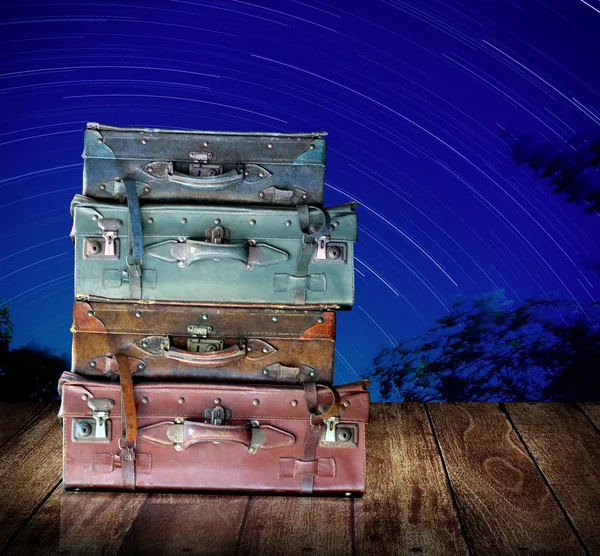 Saco de viagem vintage em tabel de madeira com coroa de estrelas no fundo do céu noturno, Viaje para o conceito de astronomia — Fotografia de Stock