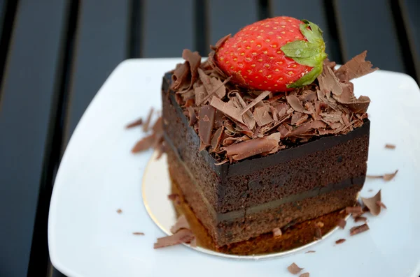 Bolo de chocolate com morango no prato branco — Fotografia de Stock