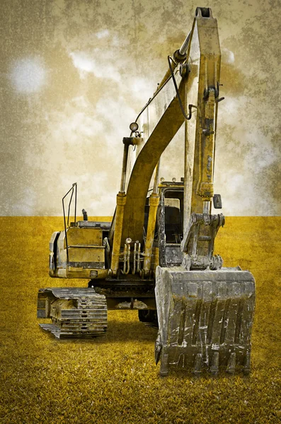 Track-type loader excavator machine on green grass field — Stock Photo, Image