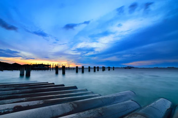 Sunset sky with bridge column in the sea — Stock Photo, Image