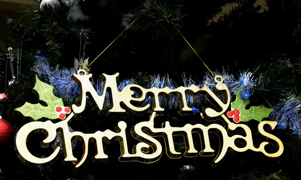 Feliz texto de Natal pendurado na árvore de Natal — Fotografia de Stock