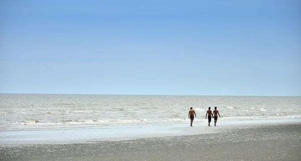 As pessoas caminham na praia — Fotografia de Stock