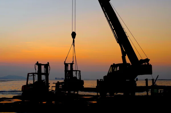 Silhouetten-Kran bei der Arbeit im Hafen — Stockfoto