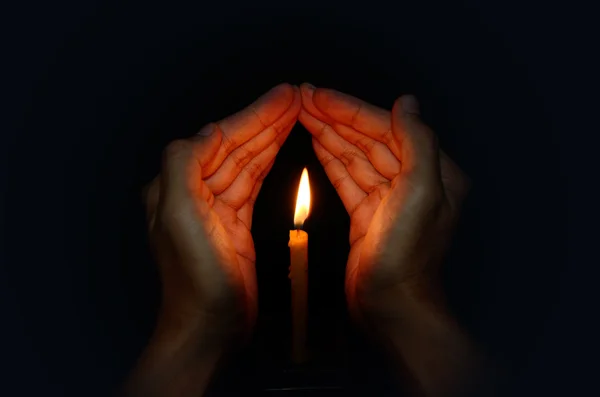 Svíčky světlo v ruce, modlitba koncepce — Stock fotografie