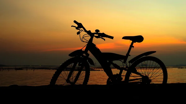 夕焼け空と山の自転車のシルエット — ストック写真