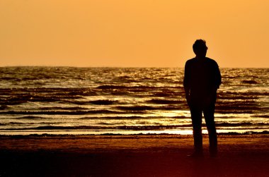 siluet adam sahilde günbatımı gökyüzü arka plan