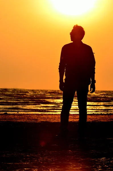 Силует чоловік на пляжі з фоном неба заходу сонця — стокове фото