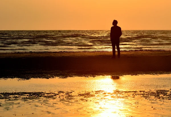 Silueta hombre en la playa con el fondo del cielo puesta del sol —  Fotos de Stock