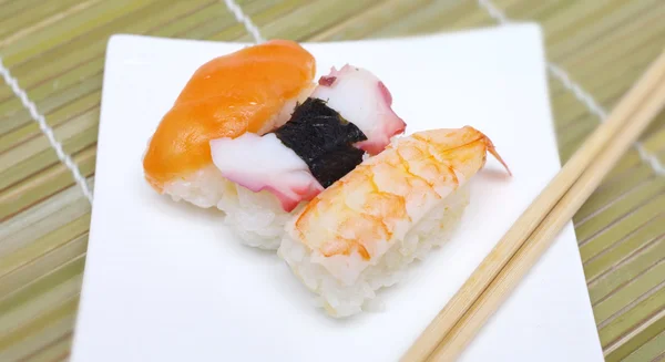 Sushi nigiri in con piatto con bastoncini di bambù — Foto Stock