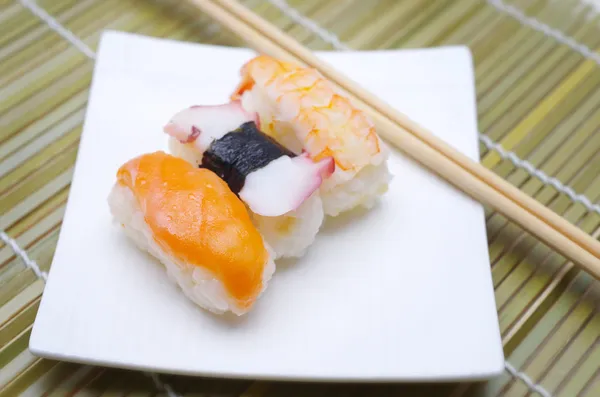 Sushi nigiri in con piatto con bastoncini di bambù — Foto Stock