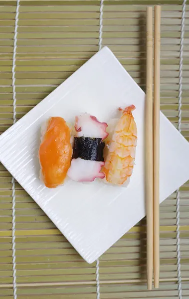 Sushi nigiri in con piatto con bastoncini di bambù — Foto Stock