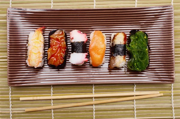 Plat de sushi nigiriin avec bâtonnets de bambou — Photo