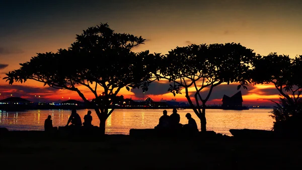 Silhueta de pessoas descansam no parque com céu de pôr-do-sol — Fotografia de Stock