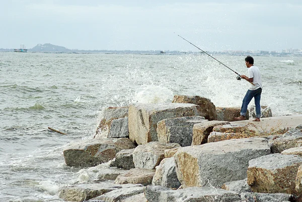 CHONBURI, TAILÂNDIA - JULHO 25: Homem não identificado que pesca com grande onda salpicando em 15 Abril 2011 na praia de Sriracha, Chonburi, Tailândia — Fotografia de Stock