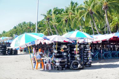 BANGSAEN, THAILAND - 19 Şubat 2022 'de Bangsaen, Chonburi, Tayland' da Hindistan cevizi ağacının yanında Bangsaen sahilindeki kiralık dükkan için yüzen tüp