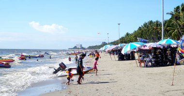 BANGSAEN, THAILAND - 19 Şubat 2022 tarihinde Bangsaen, Chonburi, Tayland 'da insanlar yüzdükten sonra plajda yürüyorlar.