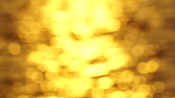 Goldenes Bokeh Licht Verschwommen Hintergrund Reflektiert Auf Meeresbrandung — Stockvideo