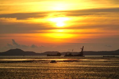 Gün batımı gökyüzü ve Si Chang adası silueti denizde