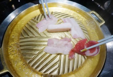 Barbekü için sıcak pirinç tava ve çiğ et, yüksek açı görünümü