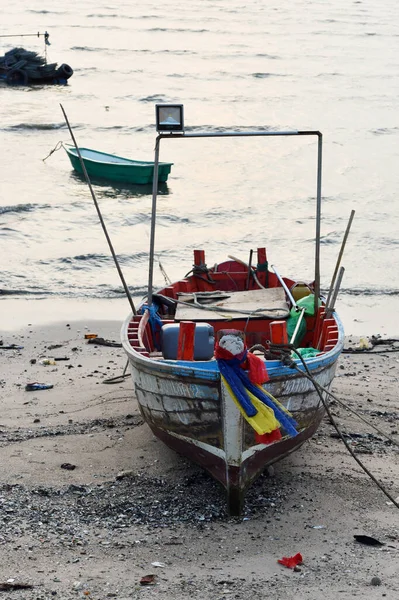 CHONBURI, THAILAND - 14 Mart 2022 'de Bangphra, Siracha, Chonburi, Tayland' da dalgaların çekildiği sahile demirlemiş balıkçı teknesi