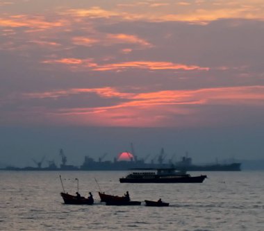 CHONBURI, THAILAND - 21 Aralık 2021 'de Siracha, Chonburi, Tayland' da gün batımında gökyüzü olan küçük balıkçı teknesinin silüeti