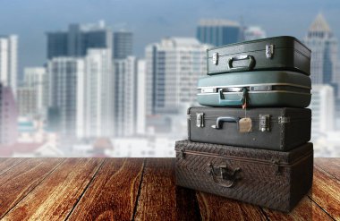 Ahşap zemin üzerinde şehir manzaralı klasik seyahat çantası.