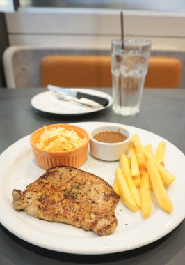 Tabakta domuz eti ve cam arka plan.