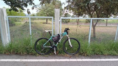 CHONBURI, THAILAND - 19 JULY : Mountain bike parking beside fence on 19 July 2022 in Bang Phra, Siracha, Chonburi, Thailand
