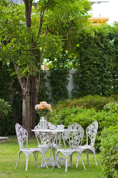 White table and chairs in the garden. Stock Photo