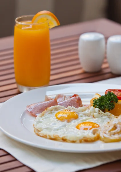 Fried eggs with bacon and fruit. — Stock Photo, Image