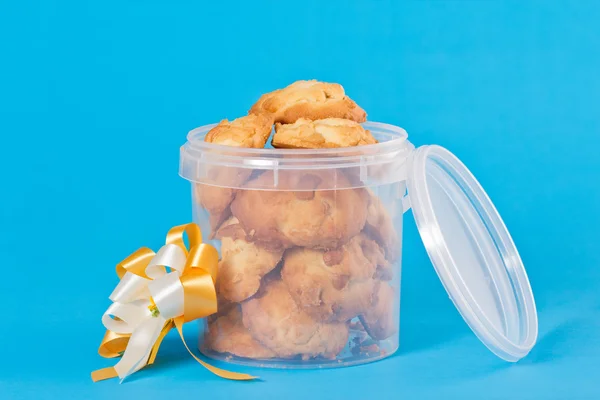 Pastel de libra y galletas en paquete de Navidad y cinta amarilla Aislado sobre fondo azul . —  Fotos de Stock