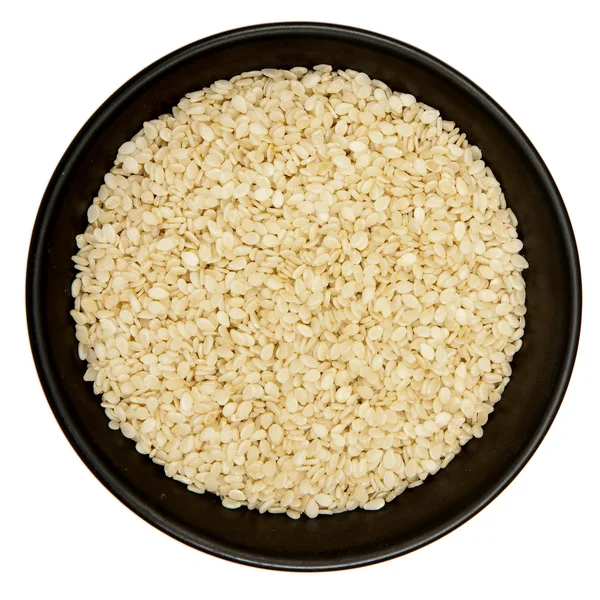 Sesame seeds in black plate — Stock Photo, Image