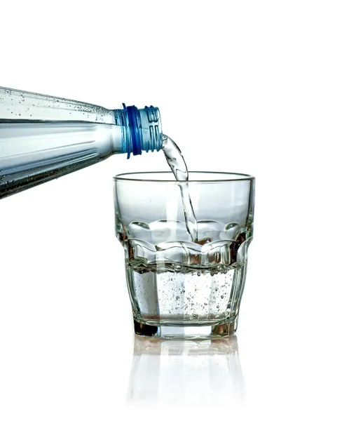 Gieten van water uit de fles naar glas — Stockfoto