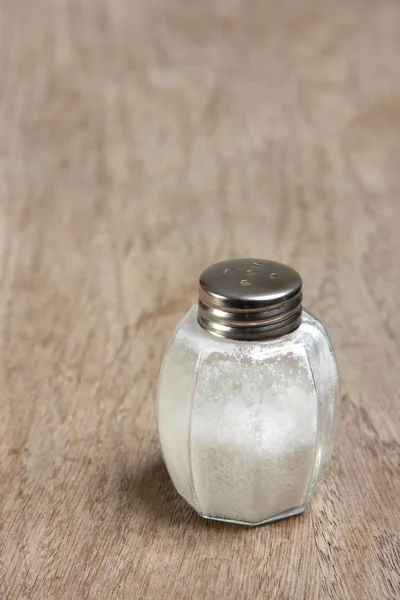 Salt shaker on wooden table — Stock Photo, Image