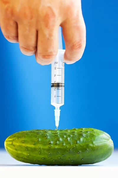 Hand making injection with syringe to cucumber — Stock Photo, Image