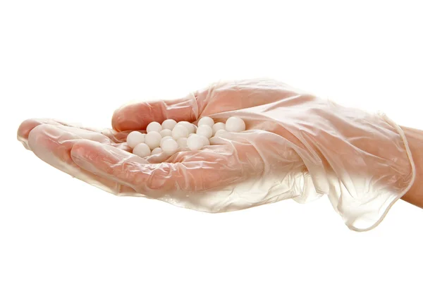 Tek kullanımlık eldiven kadının avucunda beyaz hapları — Stok fotoğraf