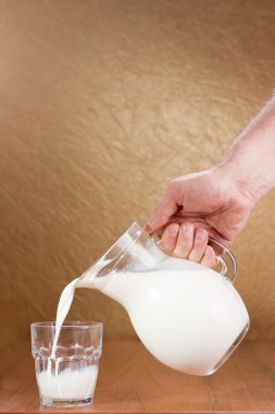 dökülen süt cam sürahi el