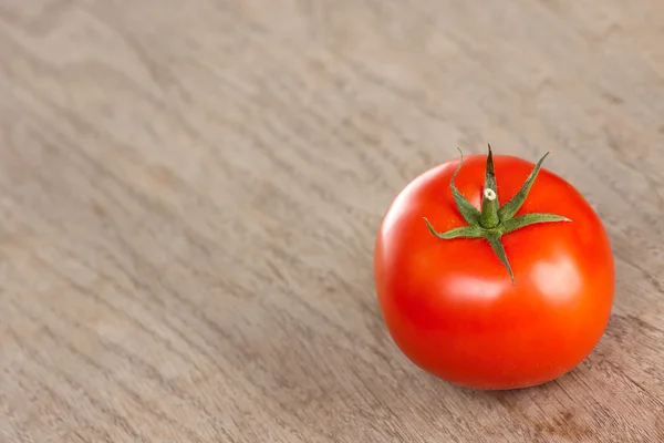 Rode tomaat op een bruine tafel — Stockfoto