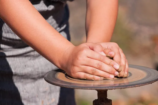 Kind handen op een wiel potter — Stockfoto