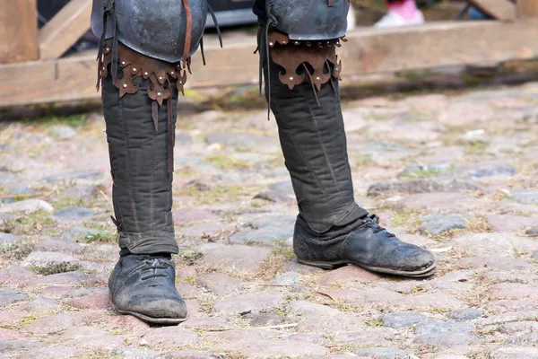 Ноги человека в сапогах темных веков — стоковое фото