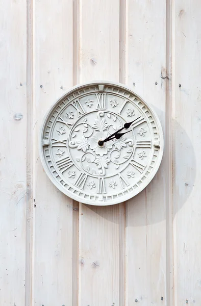 Белые часы на деревянной стене — стоковое фото
