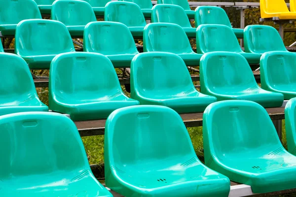 Rijen van groen plastic stoelen — Stockfoto