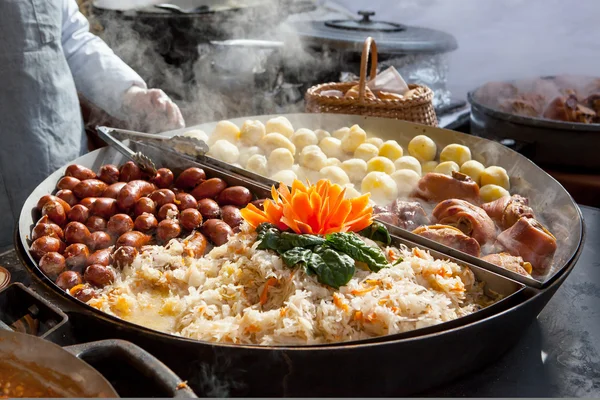 Saucisses, pommes de terre, choux et porc dans une grande casserole — Photo